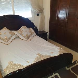 łóżko z białą pościelą i poduszkami oraz oknem w obiekcie Appartement Neuf à Louer sur Martil Maroc w mieście Martil