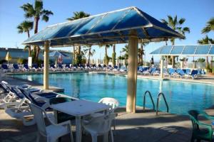 a pool with chairs and tables and a blue umbrella at San Felipe Beach Rental Condo 71-2 in San Felipe