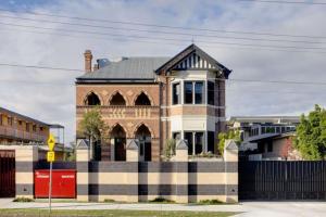 a brick building with a black fence in front of it at Highgate Hills NEW 3Bed Apartment Close to City in Brisbane