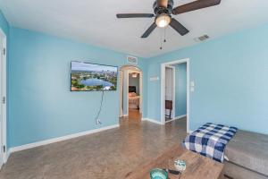 a living room with blue walls and a ceiling fan at Bella Casa St Pete FL in St. Petersburg