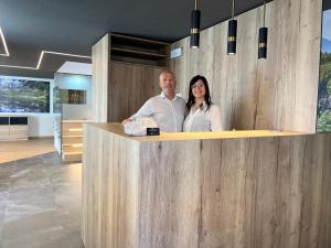 a man and woman standing behind a counter in a kitchen at Le Rocce Val di Non in Tassullo