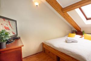 a bedroom with a bed and a desk with a window at Zsófia Apartman in Veszprém