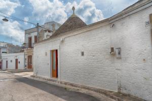un edificio de ladrillo blanco con techo en una calle en Trullo Dell'Erba en Alberobello