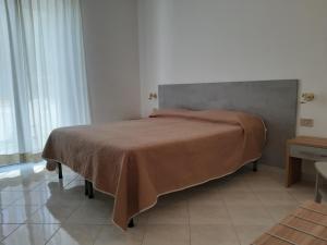 a bedroom with a bed with a brown blanket on it at Cocos Park Ischia in Ischia