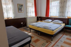 1 Schlafzimmer mit 2 Betten und 2 Fenstern in der Unterkunft Apartments Villa Kobilj in Banja Luka