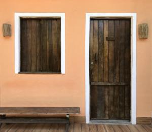 dos puertas y un banco frente a un edificio en Toca da Rapoza en Salvador