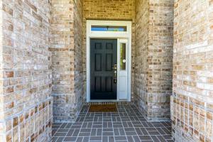 a brick hallway with a black door and a brick wall at Cozy Home on the outskirts of Tallahassee in Tallahassee