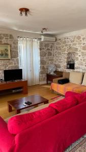 a living room with a red couch and a table at Apartman Belamaric in Šibenik