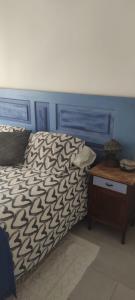 een bed met een blauw hoofdeinde en een houten tafel bij BLAU in Masnou