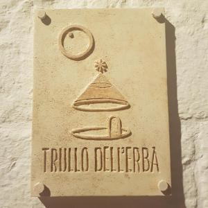 a sign on the side of a building with a triluca del fuego at Trullo Dell'Erba in Alberobello