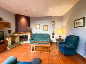 Posada Los Leones في بيرلانغا دي دويرو: غرفة معيشة مع كراسي زرقاء ومدفأة