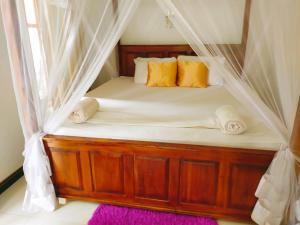 Green Ocean Bay في آروغام باي: غرفة نوم مع سرير المظلة مع الوسائد الصفراء