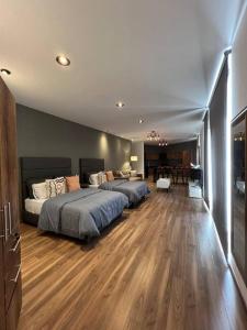 1 dormitorio con 2 camas y suelo de madera en Moderno Loft lomas 5 con terraza, en San Luis Potosí