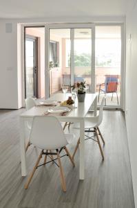una sala da pranzo bianca con tavolo e sedie bianchi di Spacious Seaside apartment A - Faraway a Lagoa