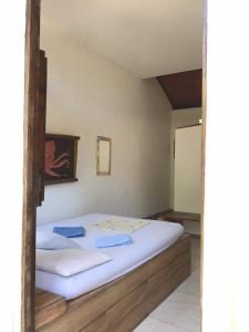 a bedroom with a bed with white sheets at Toca da Rapoza in Salvador
