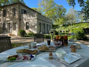 - une table avec du pain et des viennoiseries devant le bâtiment dans l'établissement Ermitage Notre Dame de Vacquieres, à Noves
