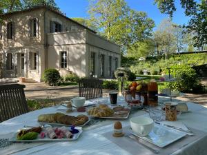 uma mesa com pão e bolos em frente a um edifício em Ermitage Notre Dame de Vacquieres em Noves