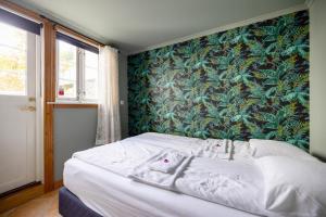 a bedroom with a bed with a green wall at Historical apartments in the heart of the old town in Stavanger