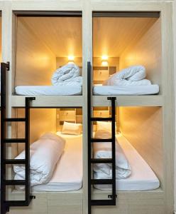 2 Etagenbetten in einem Hostelzimmer mit weißen Kissen in der Unterkunft Hong Hao 2 Hostel & Motorbikes & TOURS in Ha Giang