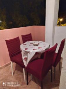 a table with red chairs and a white table cloth at Apartments Stevović in Herceg-Novi