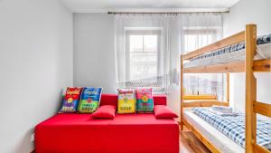 a red bed in a room with a bunk bed at Apartamenty PIAMOLA Willa Turkusowa in Kąty Rybackie