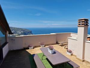 a balcony with a table and a view of the ocean at Maison Danielle in Vico Equense