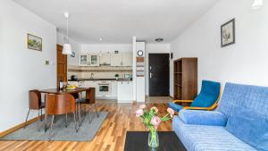 a living room with a blue couch and a table at Apartamenty PIAMOLA Willa Turkusowa in Kąty Rybackie