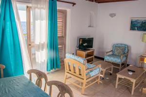 sala de estar con mesa, sillas y TV en Sunrise at Point Village-Negril, en Negril