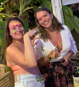 two women are posing for a picture with their face paint at The Black Sheep Hostel in Haad Rin