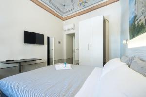 1 dormitorio con 1 cama y TV en la pared en FINARIN Guest House, en Finale Ligure