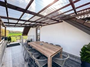 a patio with a wooden table and chairs at Noclegi Pod Lasem in Lublin