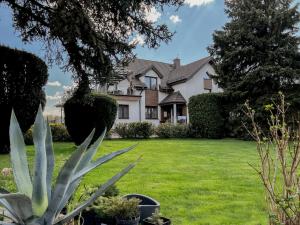 a house with a green yard with a plant at Noclegi Pod Lasem in Lublin