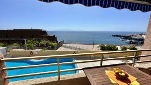 プエルト・デ・サンティアゴにあるSerigor Bahía Ocean Viewのスイミングプールと海の景色を望めます。