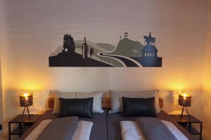 1 dormitorio con 1 cama con 2 lámparas en la pared en Mosel19 - Moderne, hochwertige Ferienwohnung en Niederfell