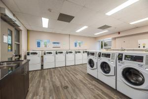 a laundry room with a row of washers and dryers at Residence & Conference Centre - Hamilton in Hamilton