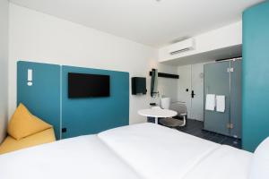 1 dormitorio con 1 cama grande y 1 mesa en GO! Hotel Ban Chang at Robinson Lifestyle Ban Chang en Ban Chang