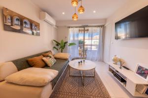 a living room with a couch and a table at Lumineux, tout confort, Wifi & Terrace & Parking in Saint-Laurent-du-Var
