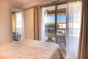 a bedroom with a bed and a large window at Lumineux, tout confort, Wifi & Terrace & Parking in Saint-Laurent-du-Var
