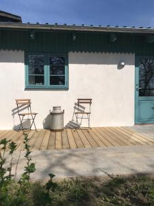 duas cadeiras num deque com uma casa em Tiny Guesthouse em Nakskov