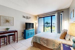 a bedroom with a bed and a tv and a window at Pirates Bay A104 in Fort Walton Beach