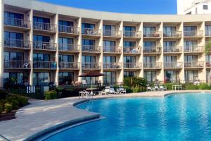 un hotel con piscina frente a un edificio en Pirates Bay A104, en Fort Walton Beach