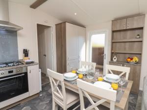 a kitchen with a table and chairs in a kitchen at Foxglove Lodge in Saltburn-by-the-Sea