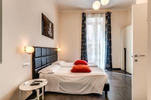 ein Schlafzimmer mit einem Bett mit einem roten Kissen darauf in der Unterkunft Deko Rome in Rom