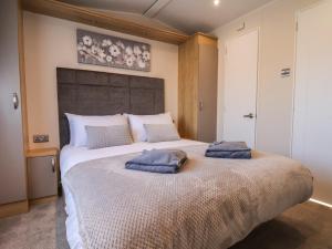 a bedroom with a large bed with two towels on it at Tulip Lodge in Saltburn-by-the-Sea