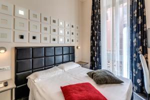 a bedroom with a bed with a black headboard and a red pillow at Deko Rome in Rome
