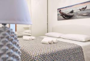 two beds in a room with a painting on the wall at Goccia Smeraldo - Gocce sul Mare in Savelletri di Fasano
