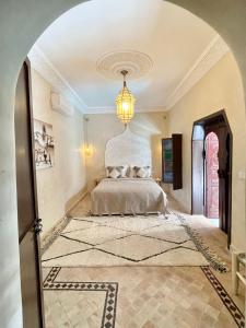 1 dormitorio con cama y lámpara de araña en Riad Jolie, en Marrakech