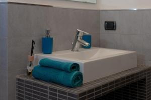 a bathroom sink with green towels on a shelf at La casa di Marigio' in Tronzano Vercellese +15 photos