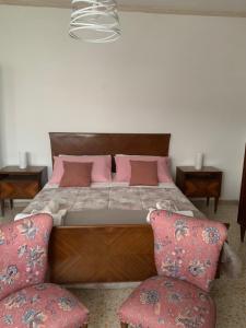 a bedroom with a large bed with pink pillows at Il giardino delle rose in Avezzano