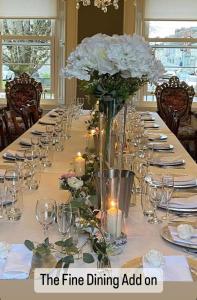een lange eettafel met witte bloemen en kaarsen bij Charlemont House Exclusive Hire Perfect for Groups of 8 to 23 persons in Moy